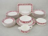 plusieurs assiettes, tasses et soucoupes rouges et blanches posées sur une table
