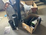 une boîte contenant divers objets posée par terre à côté d'une pile de cartons