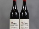 two bottles of red wine sitting on top of a table