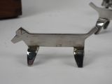 pair of silver dog figurines on a white surface