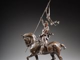 statue of a man on a horse with a flag on a wooden base