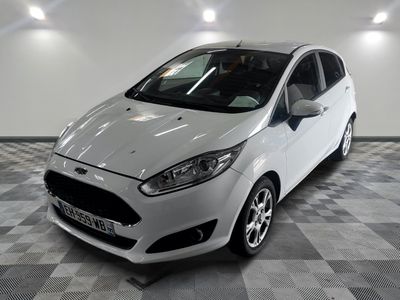 La voiture blanche est garée sur le sol à damier du garage.