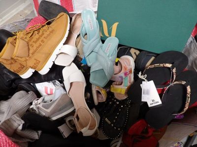 de nombreuses paires de chaussures dans un panier posé par terre