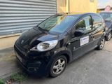 La petite voiture noire est garée au bord de la rue.