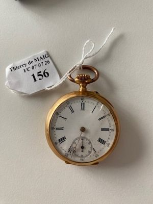 a gold pocket watch hanging on a wall with a price tag