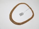 an image of a gold necklace with a tag attached to it