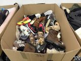 plusieurs paires de chaussures dans une boîte en carton posée sur le sol