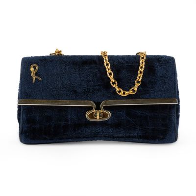 a blue velvet handbag with gold chain handles and a chain strap