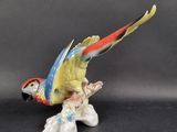 a figurine of a parrot sitting on a branch