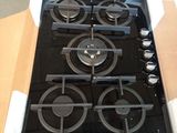 une plaque de cuisson noire à quatre feux, emballée dans un carton