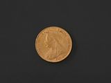 a close up of a gold coin on a black surface