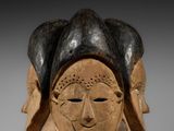un gros plan sur une sculpture en bois représentant le visage d'une femme
