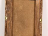 an old picture frame with a label on it sitting on a white surface