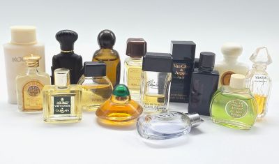 de nombreux flacons de parfum de toutes sortes posés sur une surface blanche