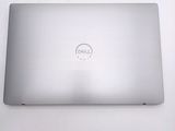 dell laptop computer sitting on a white surface with a dell logo on the screen