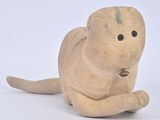 une petite peluche allongée sur une surface blanche