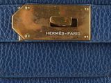 a close up of a blue leather purse with a brass clasp