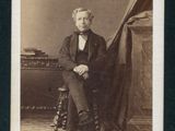 portrait d'un homme assis sur une chaise, sur une photo en noir et blanc