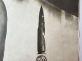 an old black and white photo of a woman with a bullet in her mouth