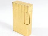 un briquet doré posé sur une surface blanche