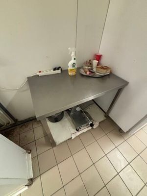a small kitchen with a table and a refrigerator