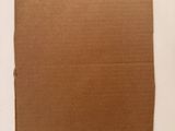 a piece of cardboard on the table with a piece of paper on it