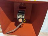 a close up of a red box with a wire attached to it