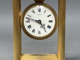 a gold clock with roman numerals on the face
