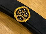 a black belt with a gold and black emblem on it