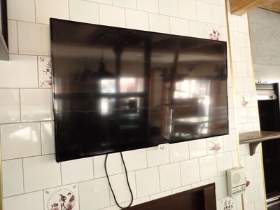 un téléviseur à écran plat fixé au mur au-dessus d'une cheminée