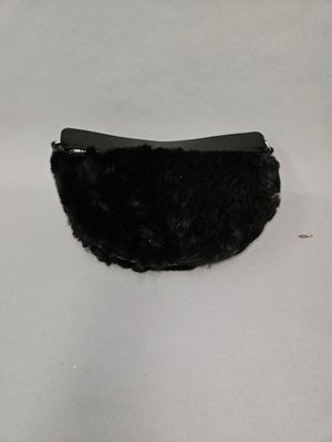 a black purse with fur on it on a white surface