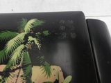 a black plate with a picture of a palm tree on it