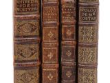 trois livres sont empilés sur une surface blanche