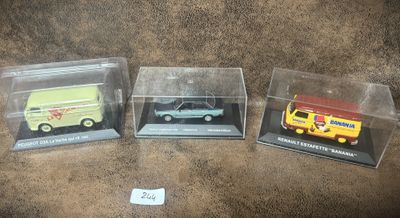 trois modèles différents de voitures sont exposés dans des boîtes transparentes posées sur une surface marron