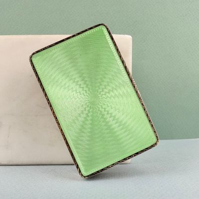 un sac à main vert posé sur une table à côté d'un ordinateur portable