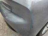 a close up of a car ' s front bumper with a denting on it