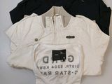 three t - shirts that are sitting on top of a white table