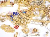a pile of gold jewelry on a white surface
