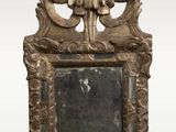 a small mirror with a gold frame on the wall