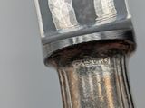 a close up of a silver vase with a silver handle