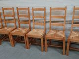six wooden chairs are lined up against a wall in a garage