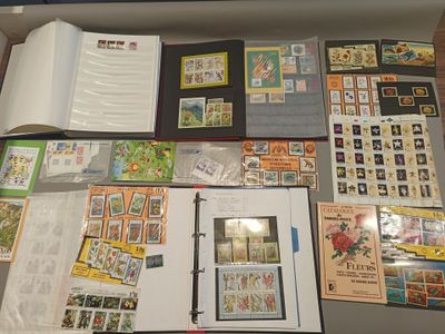 beaucoup de timbres posés sur une table, à côté d'un livre