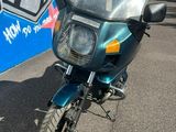 a blue motorcycle parked in front of a blue wall