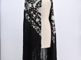 a black and white shawl with fringes on a mannequin mannequin