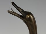 a bronze sculpture of a duck with its mouth open