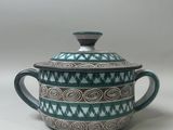 a close up of a teapot with a lid on a table