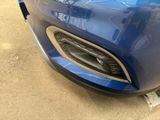 a close up of a blue car that is parked on the street