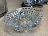 a glass juicer sitting on a table next to a bottle