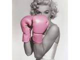 photographie en noir et blanc d'une femme portant des gants de boxe roses