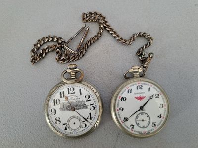 deux montres de poche posées sur une table